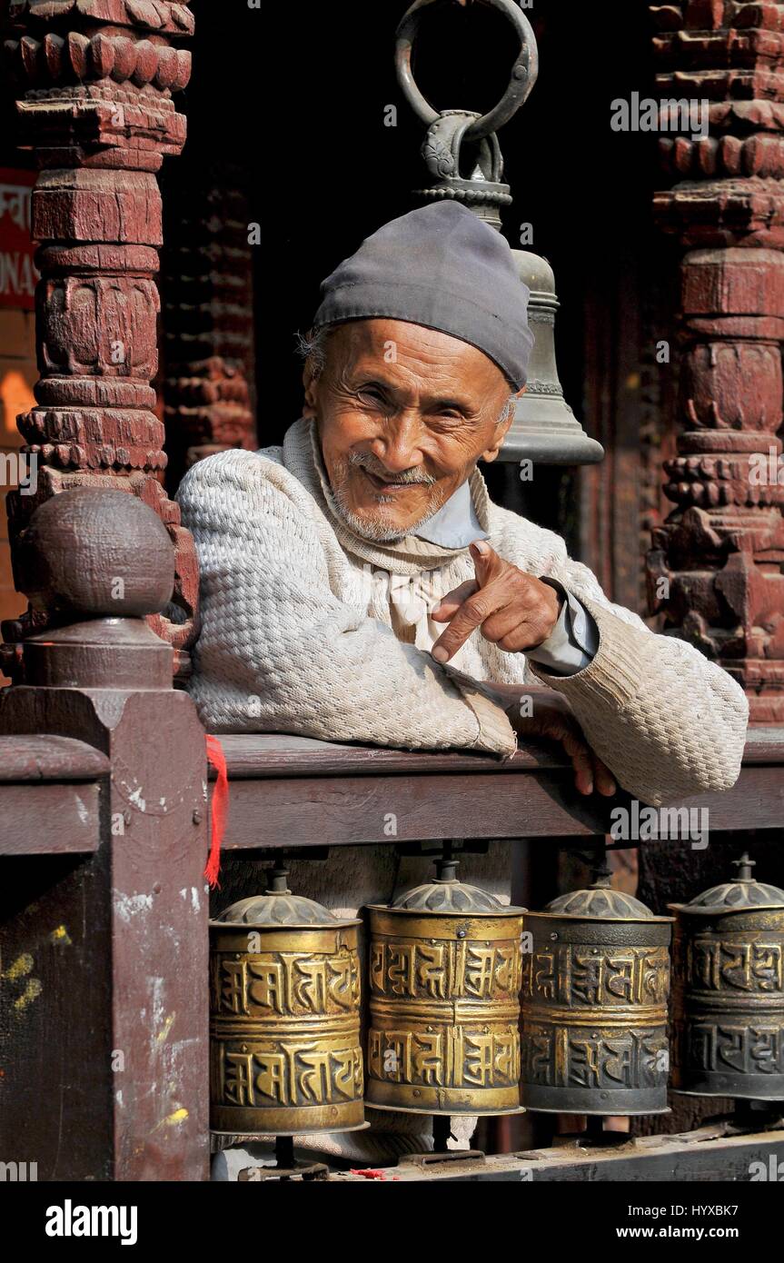 Nepal, Patan, Old man and prayer wheels in Golden temple Patan Buddhist