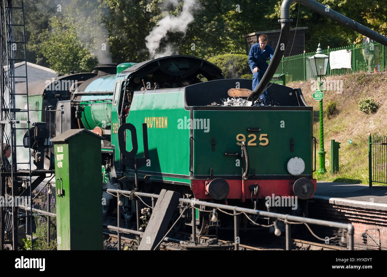Ropley, UK - 19 September, 2015: An engineer filling the water tender of a vintage steam locomotive at the Mid-Hants Watercress railway station of Rop Stock Photo