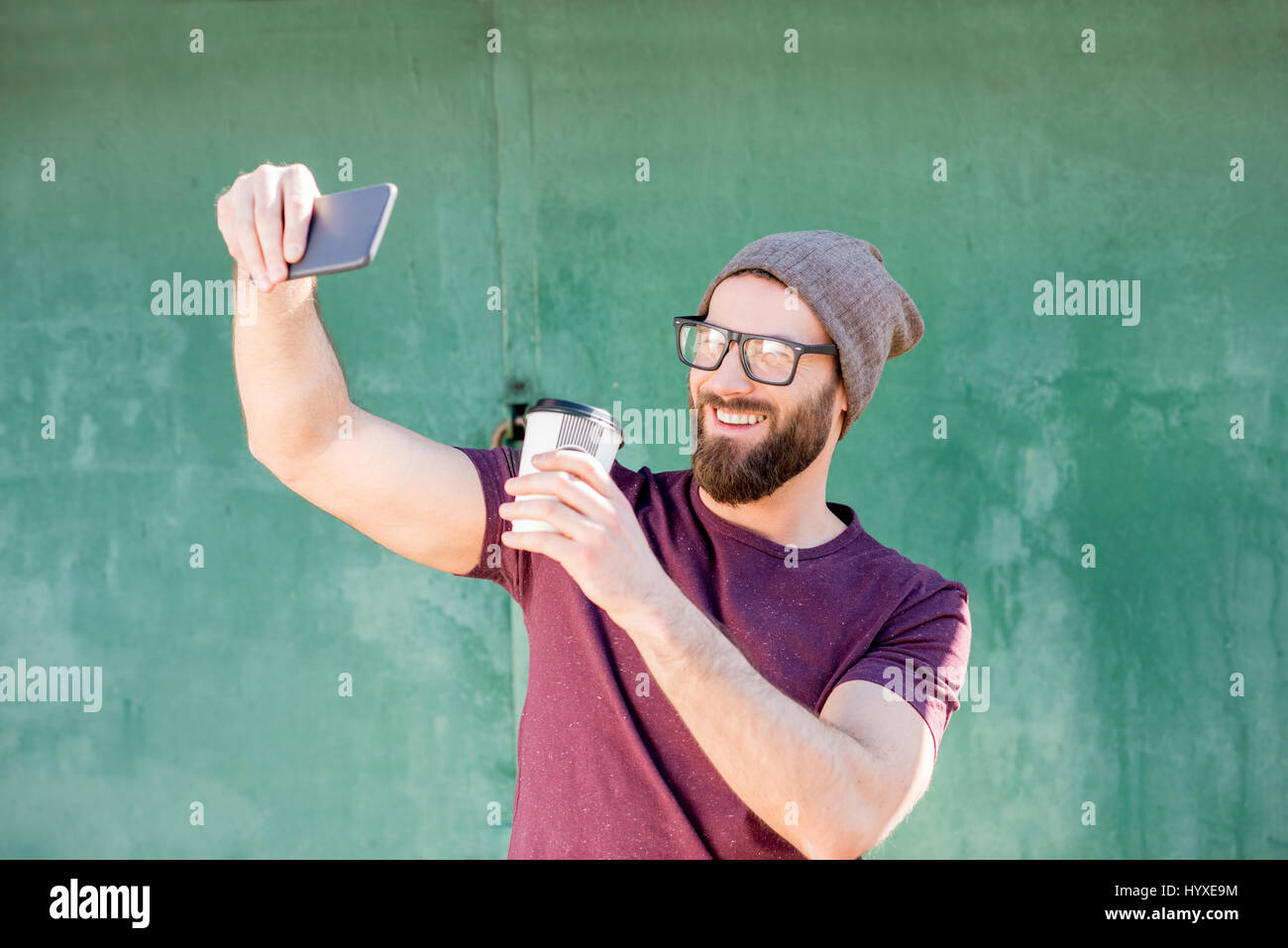 Man with coffee on the green background Stock Photo - Alamy