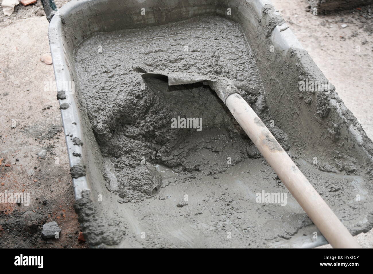 Wheelbarrow full of concrete and shovel Stock Photo Alamy