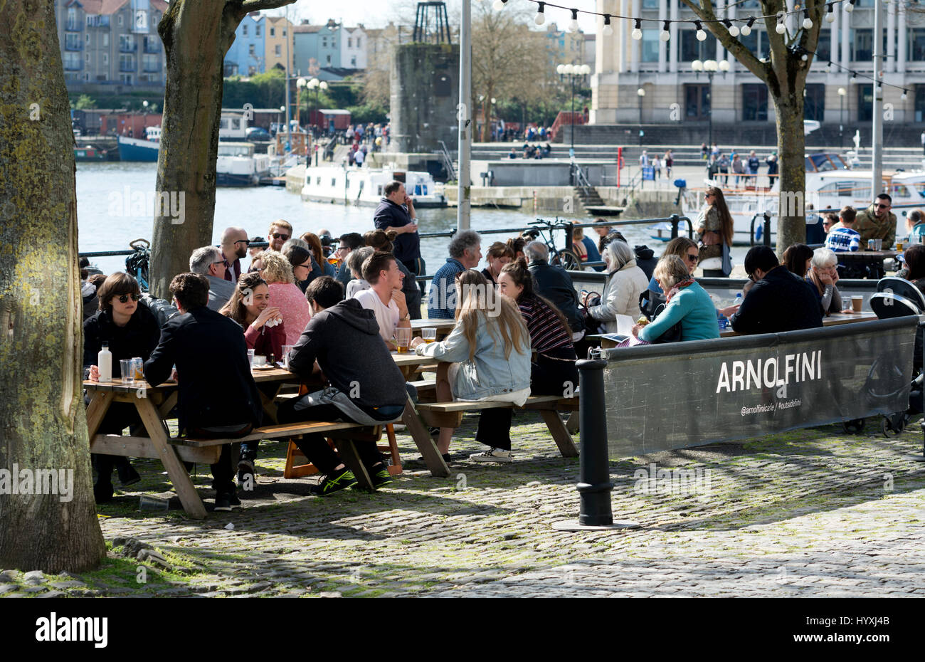 People sat eating and drinking at tables outside the Arnolfini, Bristol, UK Stock Photo