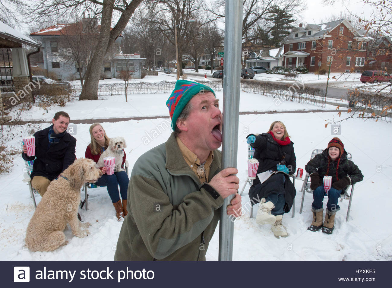 a-man-gets-his-tongue-stuck-to-a-pole-while-his-family-laughs-in-the-HYXKE5.jpg
