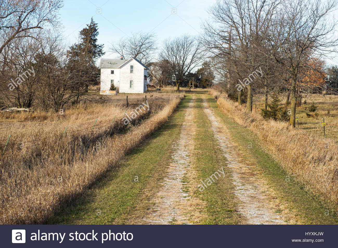 A country road leads to an old farm house in rural Nebraska Stock Photo