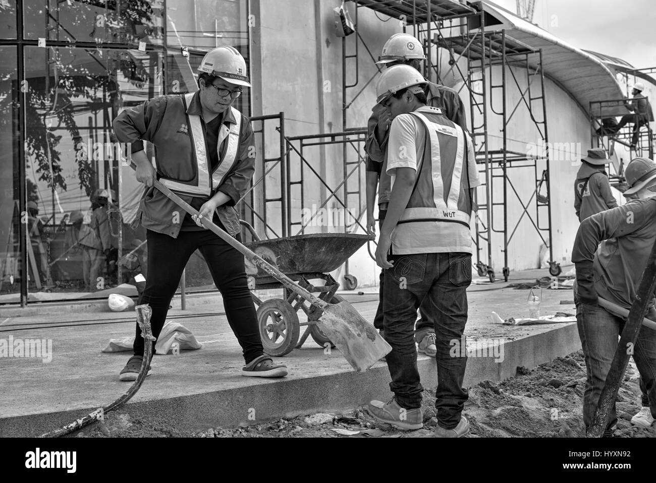 Woman working on building site. Female builder, construction site, Thailand Southeast Asia Black and white photography Stock Photo