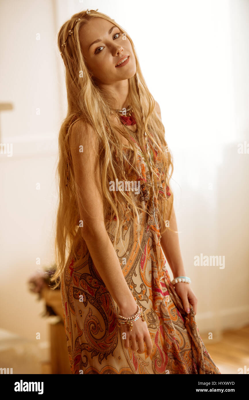 Beautiful young hippie woman in dress smiling at camera Stock Photo