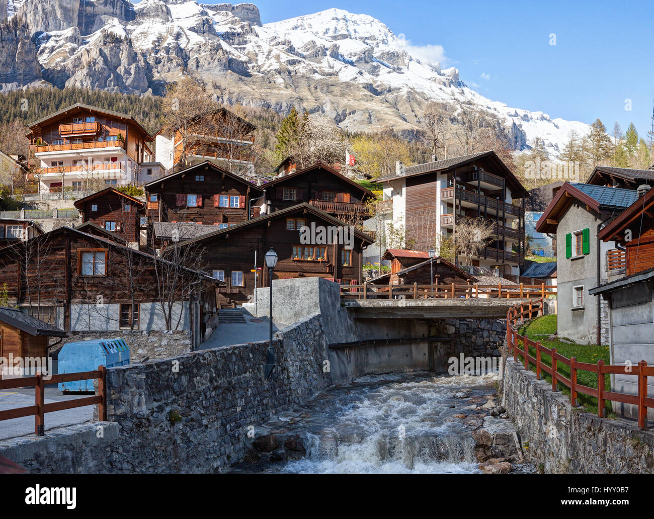 Typical Swiss houses along the Dala river on a spring day in Leukerbad, Valais canton, Switzerland. Stock Photo
