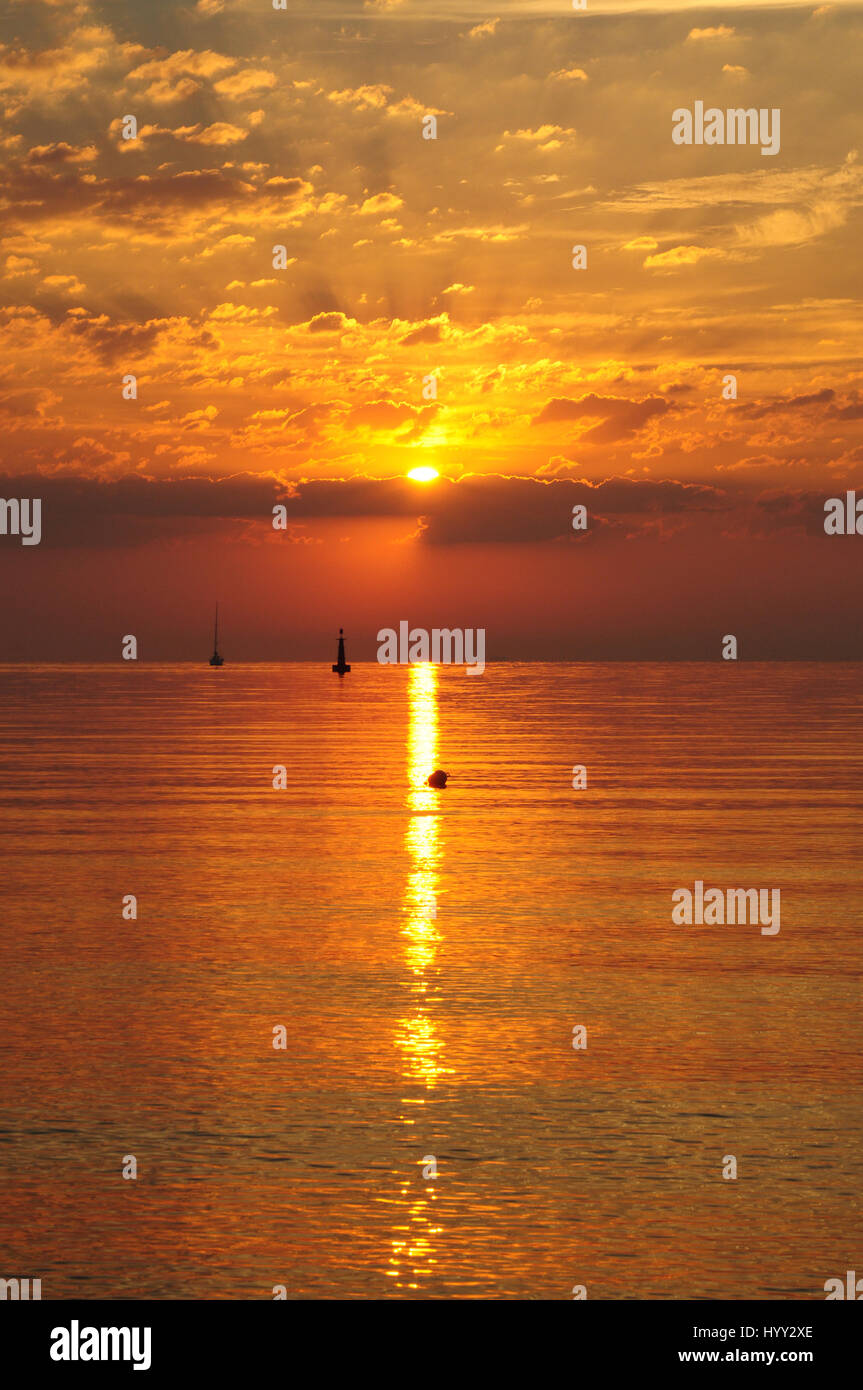 Golden sunrise over the baltic sea in gdynia, Poland - sun in clouds and boat silhiuette on the horizon - golden hour Stock Photo