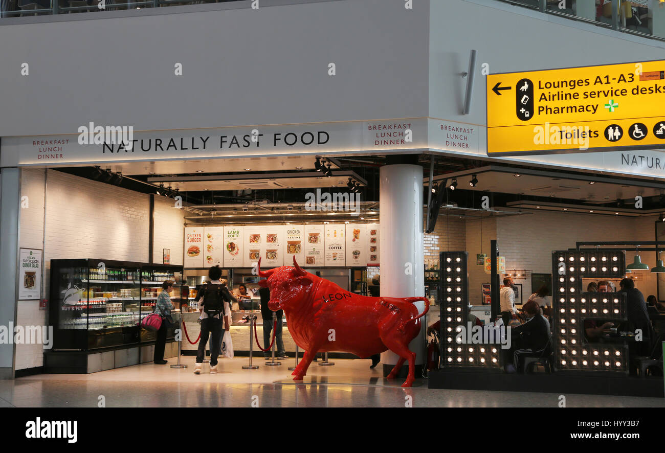 England Heathrow Airport Terminal Two Leon Naturally Fast Food Restaurant With Cow Statue Outside Stock Photo