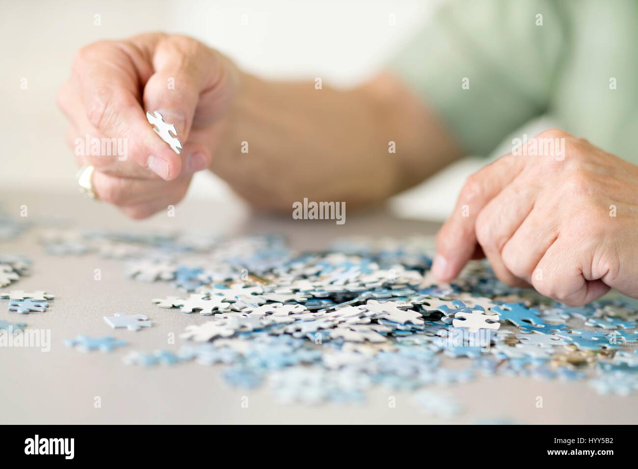 Senior man doing a jigsaw puzzle. Stock Photo