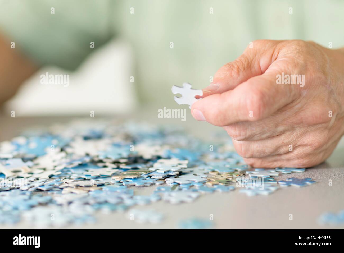 Senior man doing a jigsaw puzzle. Stock Photo