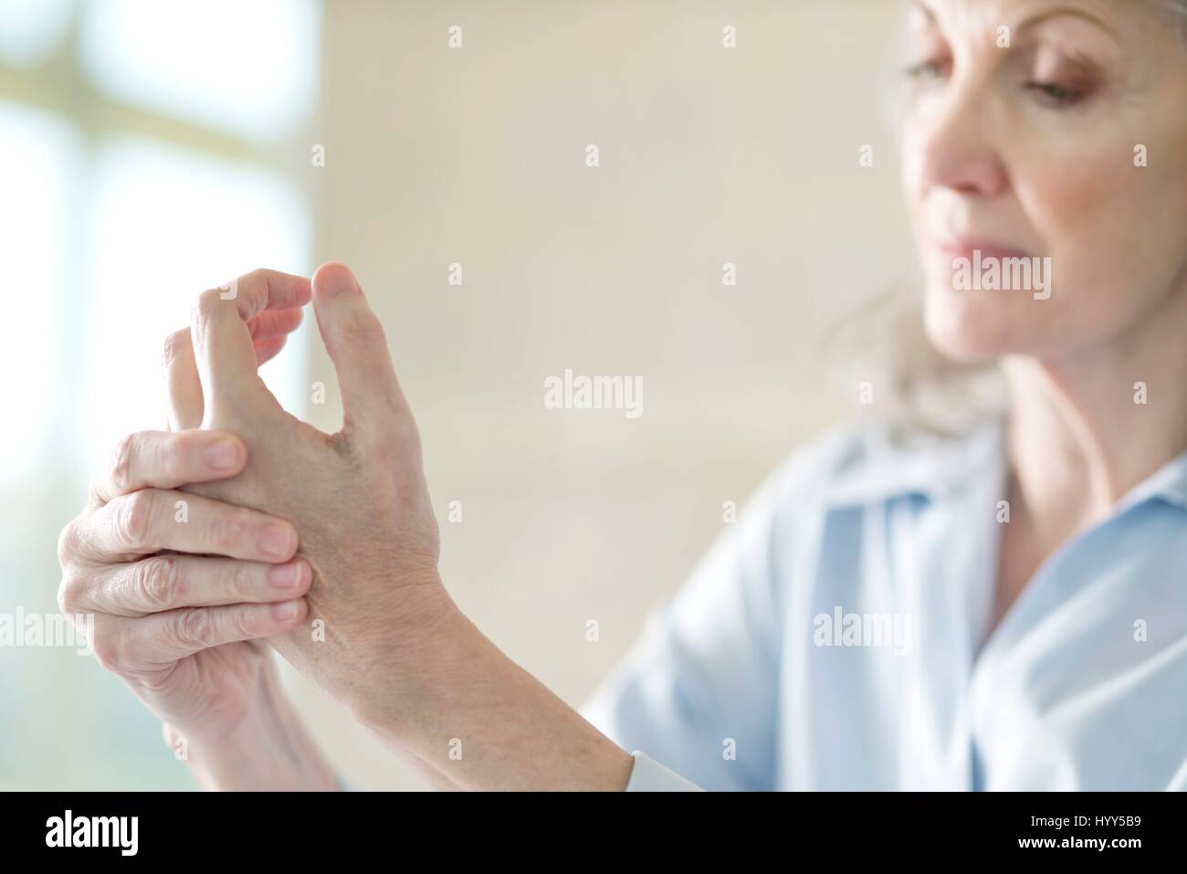 Senior woman holding painful hand. Stock Photo