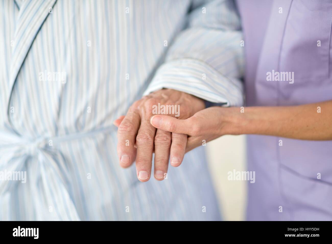 Care worker holding senior patient's hand. Stock Photo