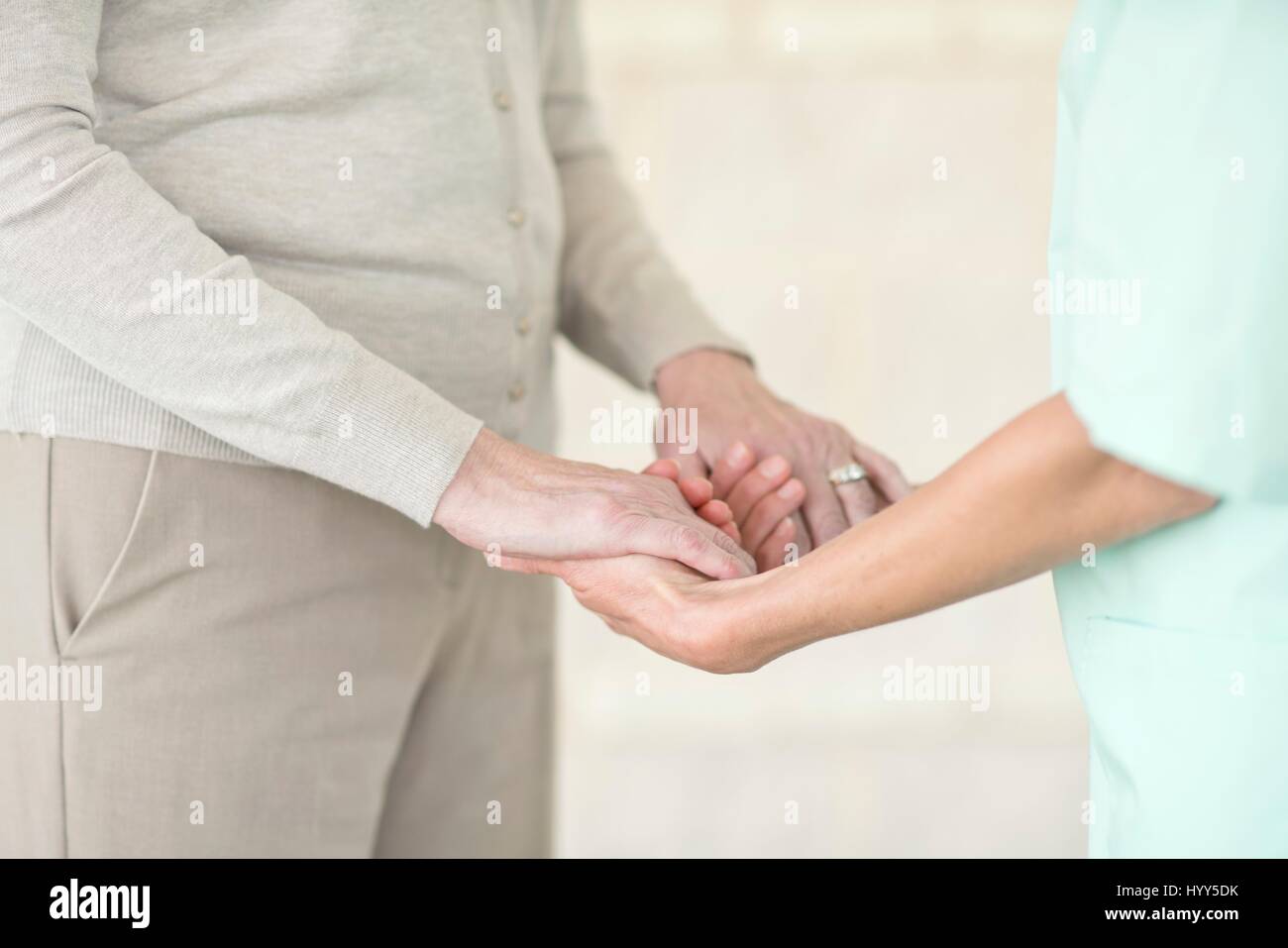 Care worker holding senior woman's hands. Stock Photo