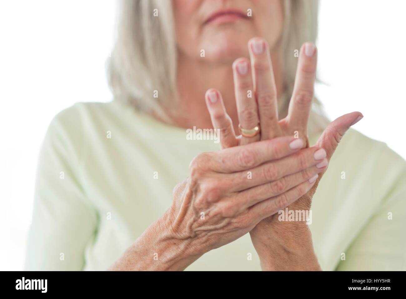 Senior woman rubbing painful hand. Stock Photo