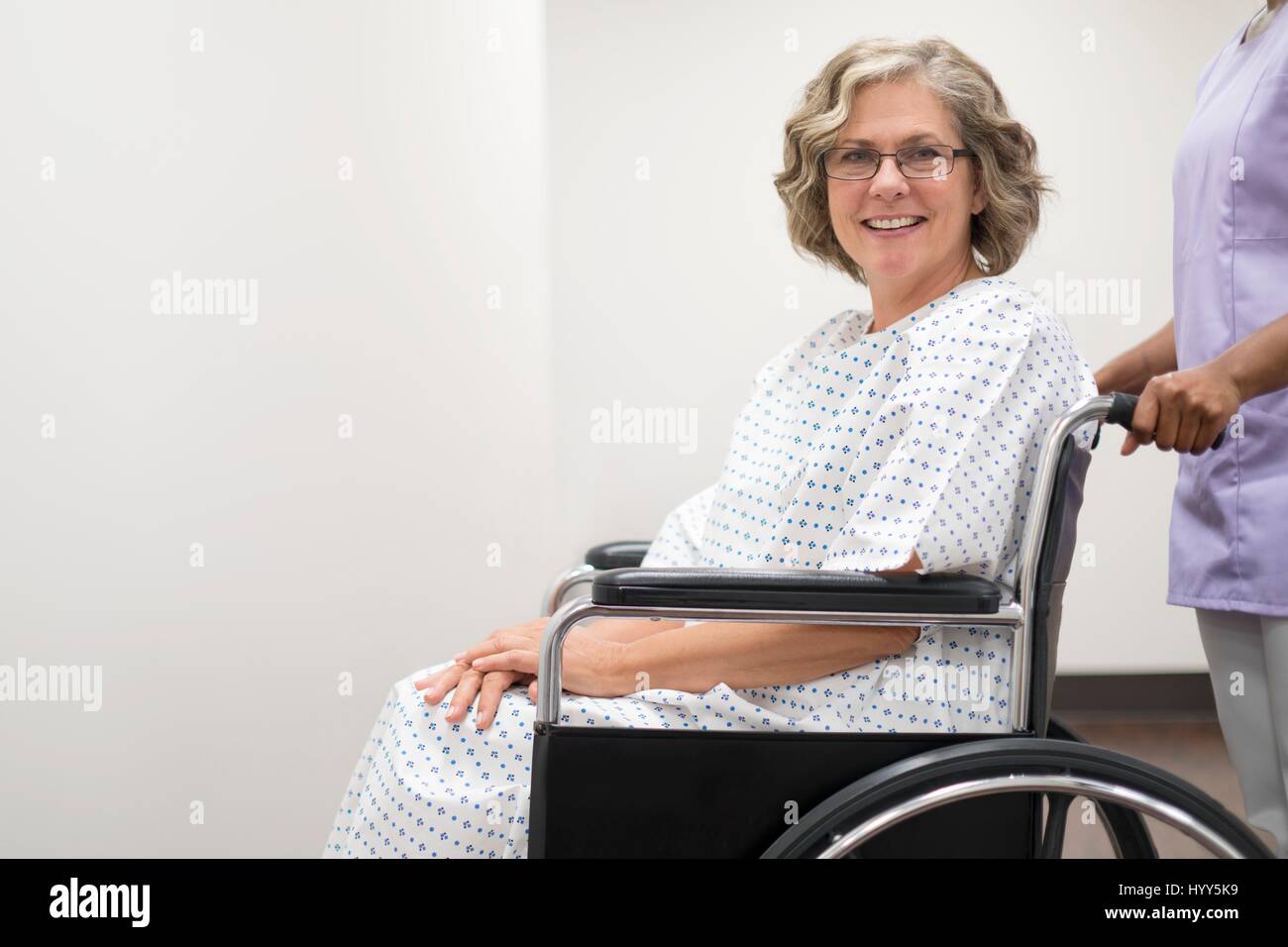 Nurse pushing female patient in wheelchair. Stock Photo