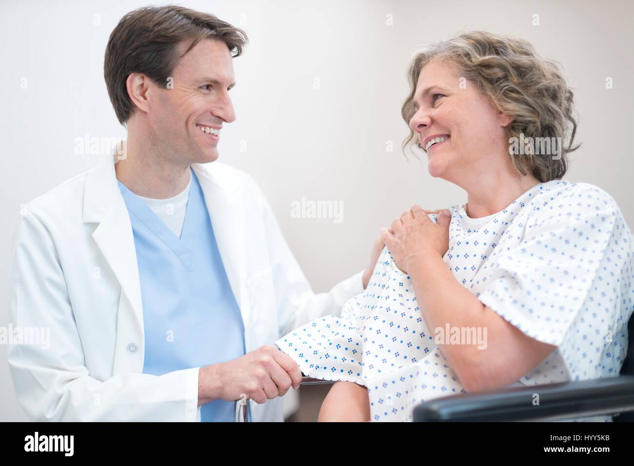 Male doctor smiling at mature female patient. Stock Photo