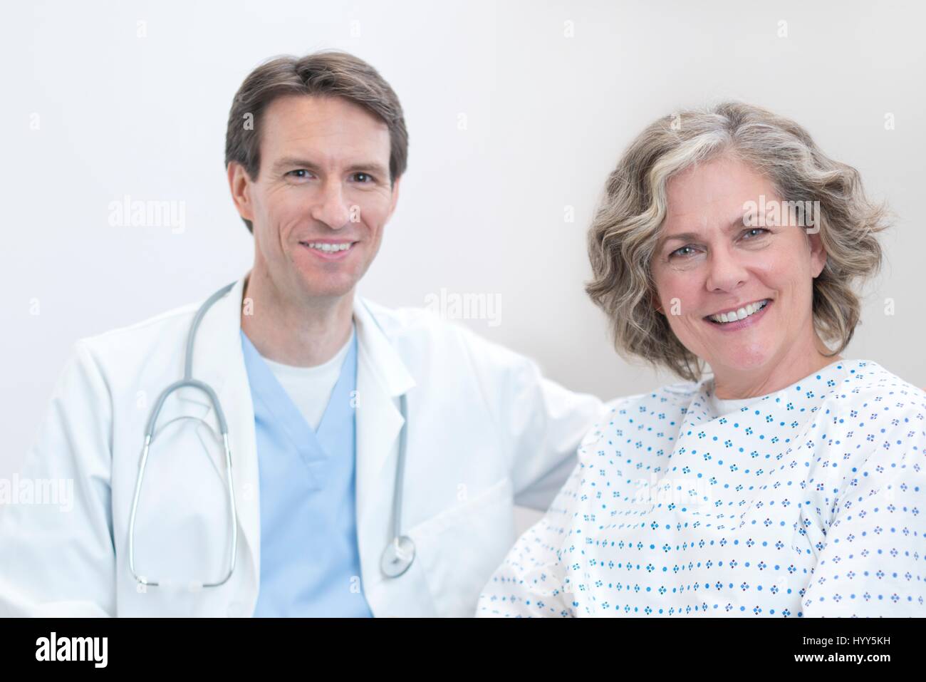 Male doctor and female patient smiling towards camera. Stock Photo