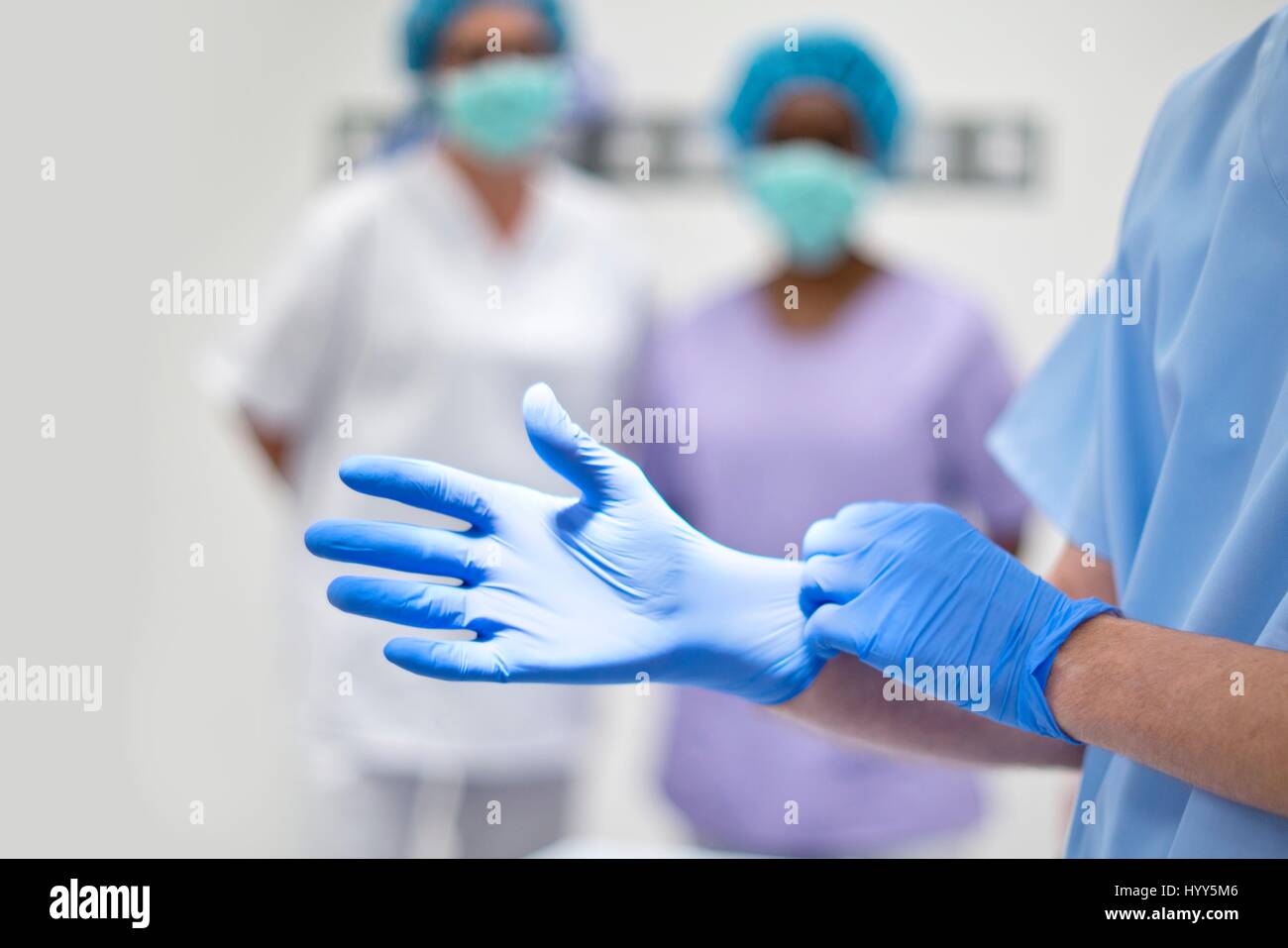 Surgeon putting on latex glove. Stock Photo