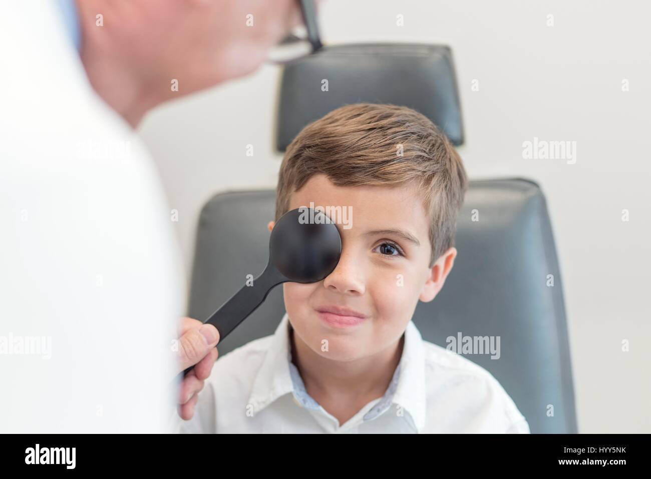Male optician testing boy's eyesight. Stock Photo