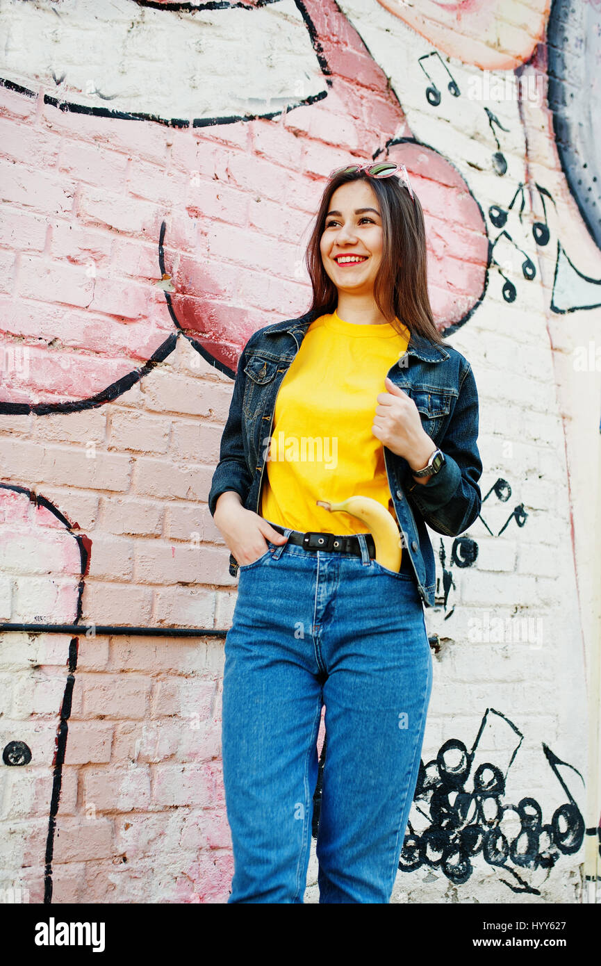 Beautiful teenage girl wear yellow t-shirt and jeans near graffiti wall  Stock Photo - Alamy