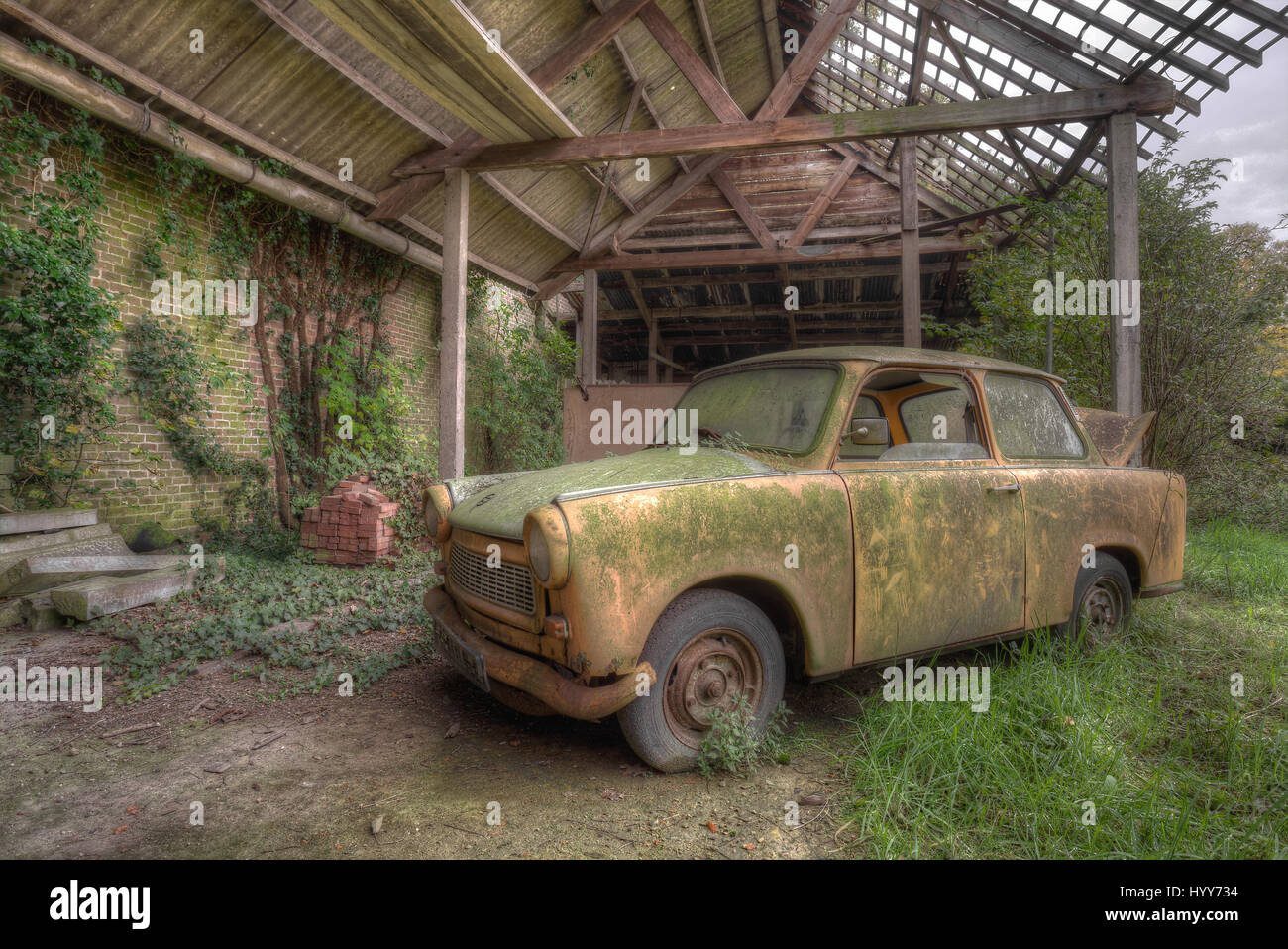 A Trabant car. STUNNING images reveal the vulnerable beauty of abandoned cars that have been left to rust over the years. The collection of spectacular images show how a Volkswagen Beetle, Citroën C2 and even a Ferrari have been taken over by nature and piles of rubble. In other shots, a Mercedes Benz is overgrown with ivy and an old-fashioned BMW has been left in a garage with a collapsing roof and debris on the floor. A Ford vehicle has also been forgotten in the woods and one car even appears to have a tree growing from it. The haunting images were taken by Belgian security guard, Kenneth P Stock Photo