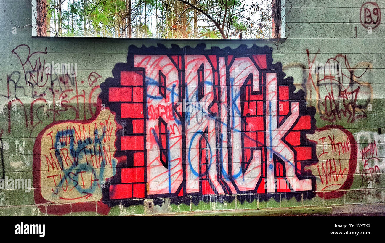 WHITAKERS, NORTH CAROLINA: EERIE photographs reveal the crumbling remains of an abandoned high school set in the heart of the American South that has been taken over by graffiti and seemingly used as a canvas for an ambitious unknown poet. Spooky pictures show former classrooms where the ceiling has caved in, exposing the building to the elements outside and how the school has been adorned with graffiti throughout since it closed years ago. Other images show the school’s overgrown gardens, whilst others inside show wooden planks strewn across the floor. The stunning shots were taken by busines Stock Photo