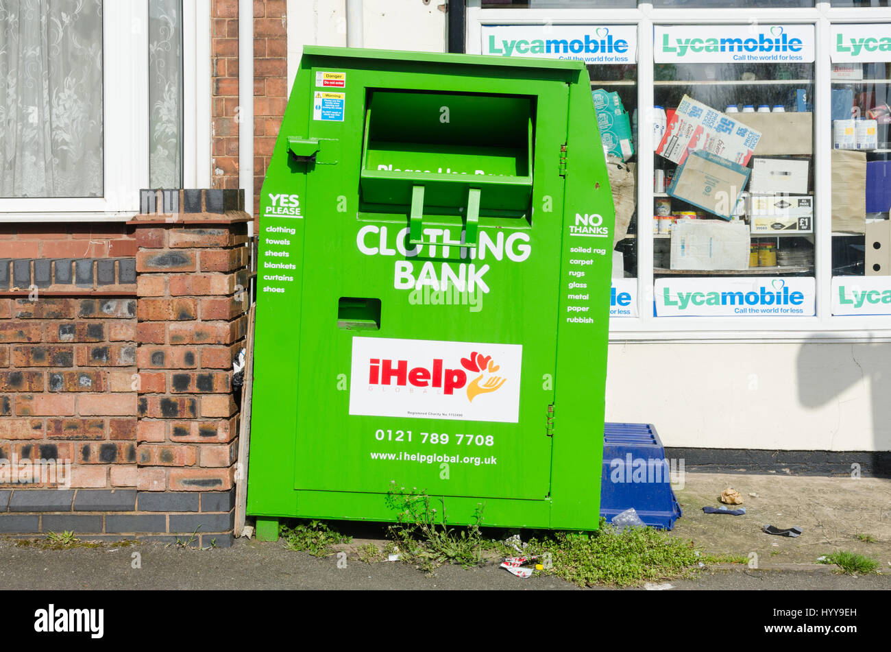 Bright green iHelp clothing bank charity recycling bin Stock Photo