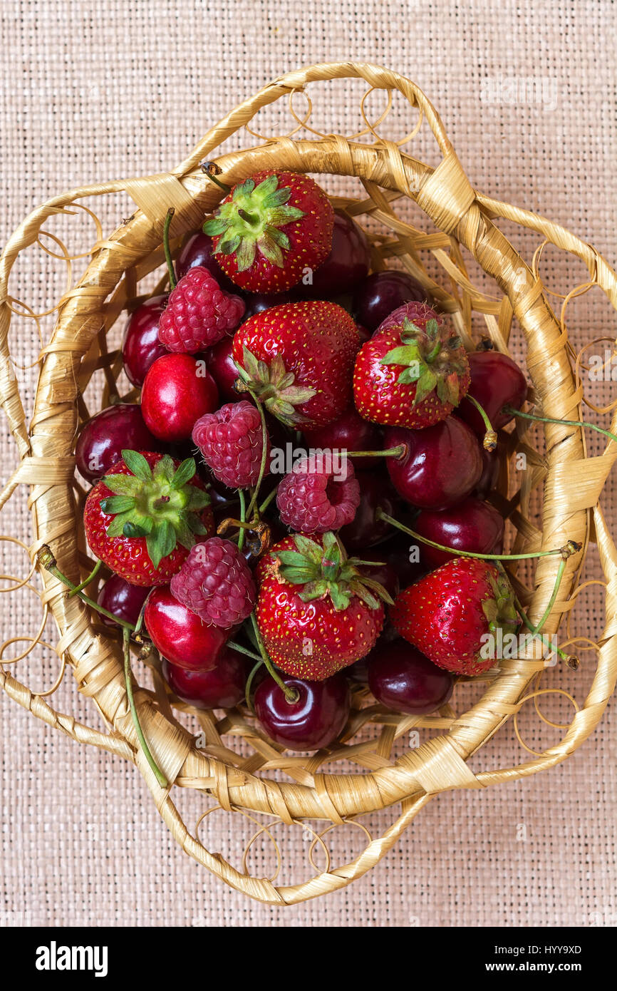 Strawberry, cherry and raspberry in the basket on sackcloth Stock Photo ...