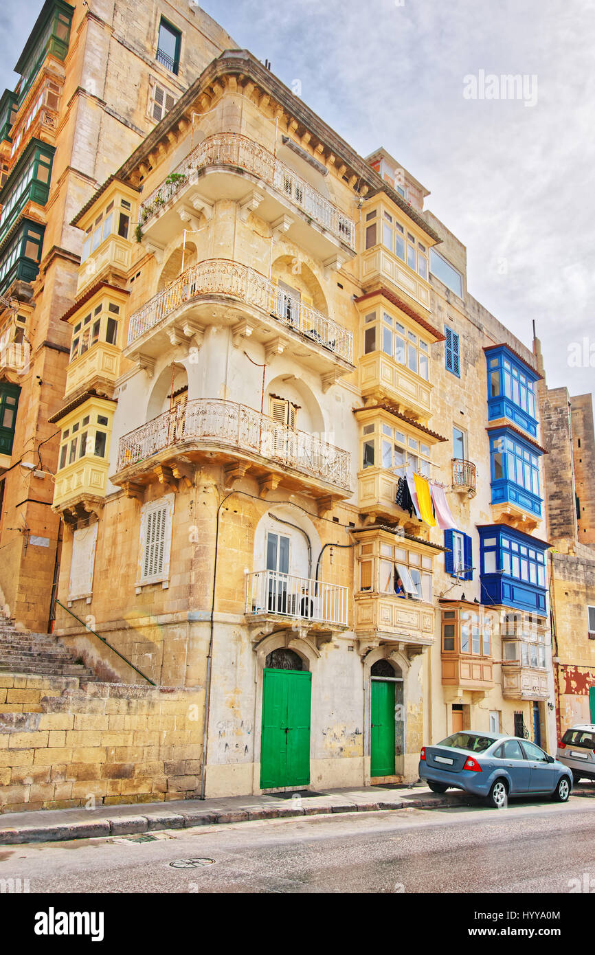 Old street with traditional houses in the city center in Valletta, Malta Stock Photo