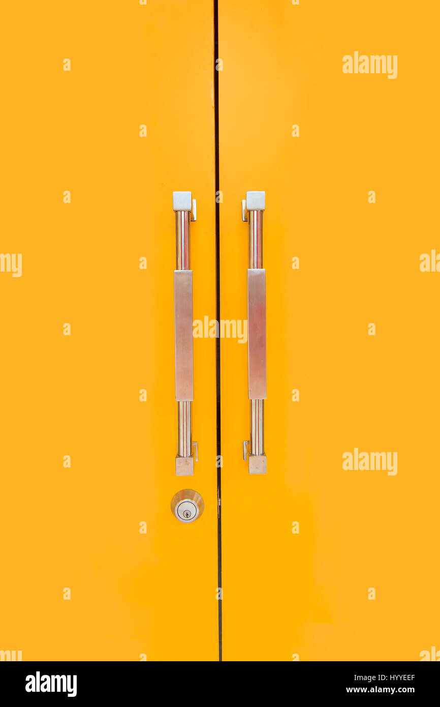 Yellow door and glossy handles with security lock Stock Photo Alamy