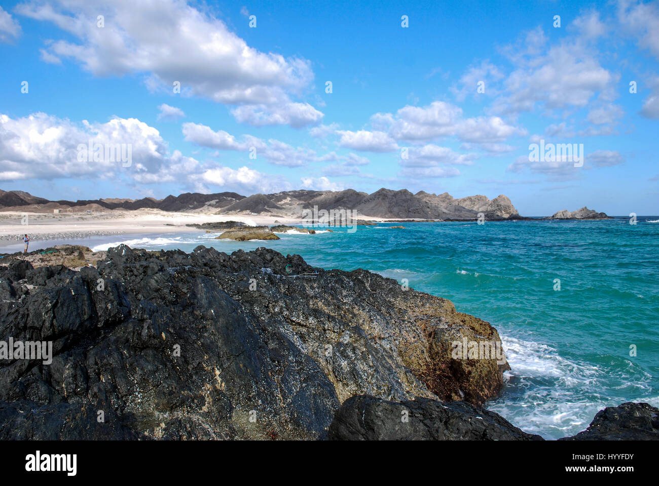 Rocky beach blue sky and clouds Stock Photo - Alamy