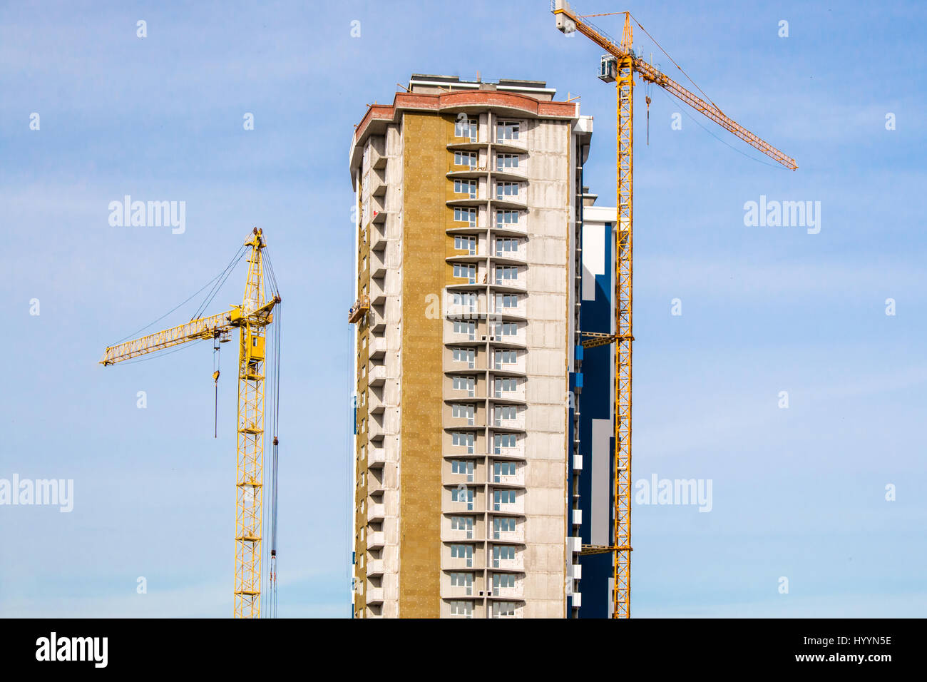Crane and high-rise building under construction works against sun blue ...