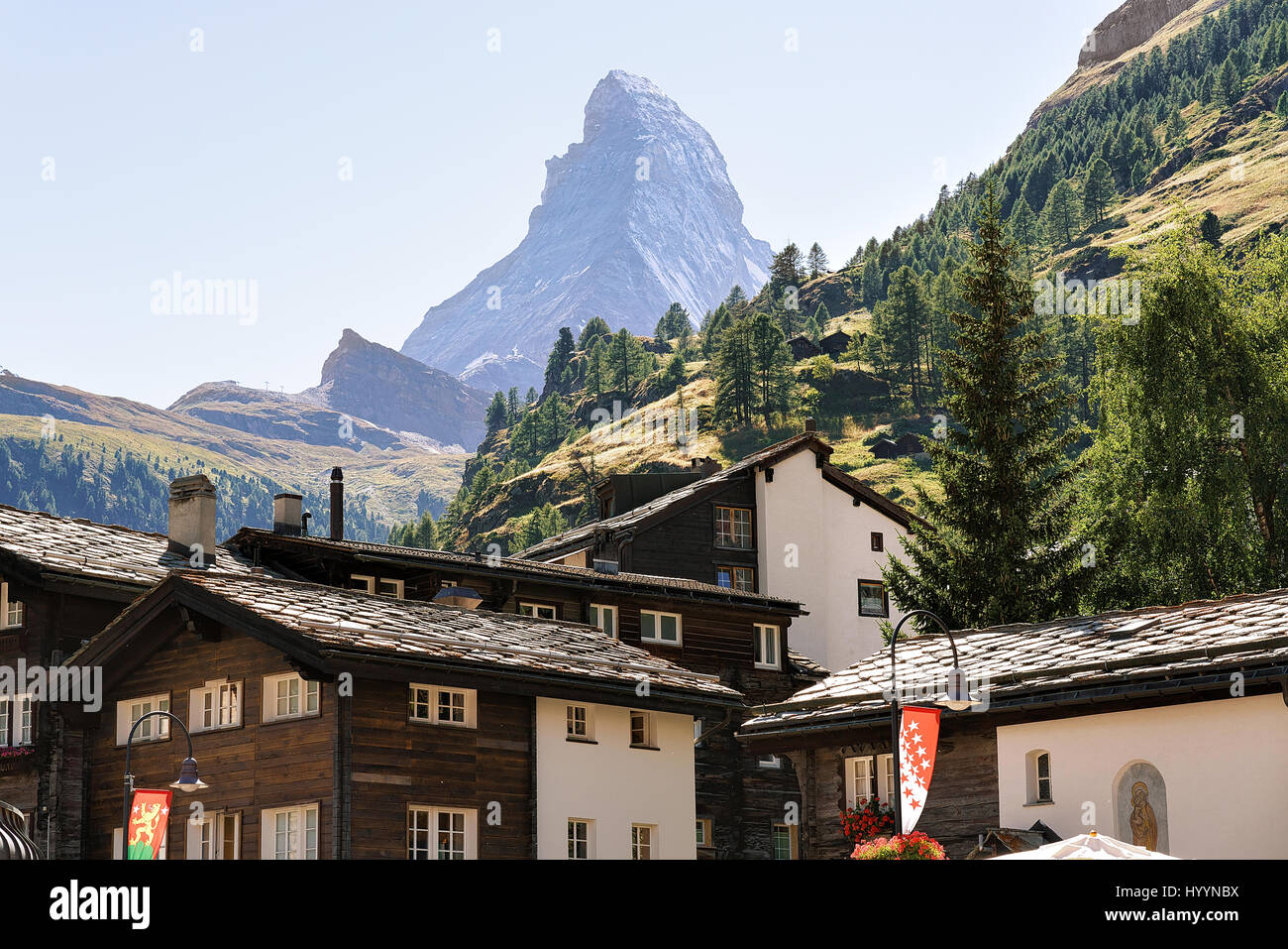 Traditional Swiss Chalets in Zermatt with Matterhorn peak with flags ...