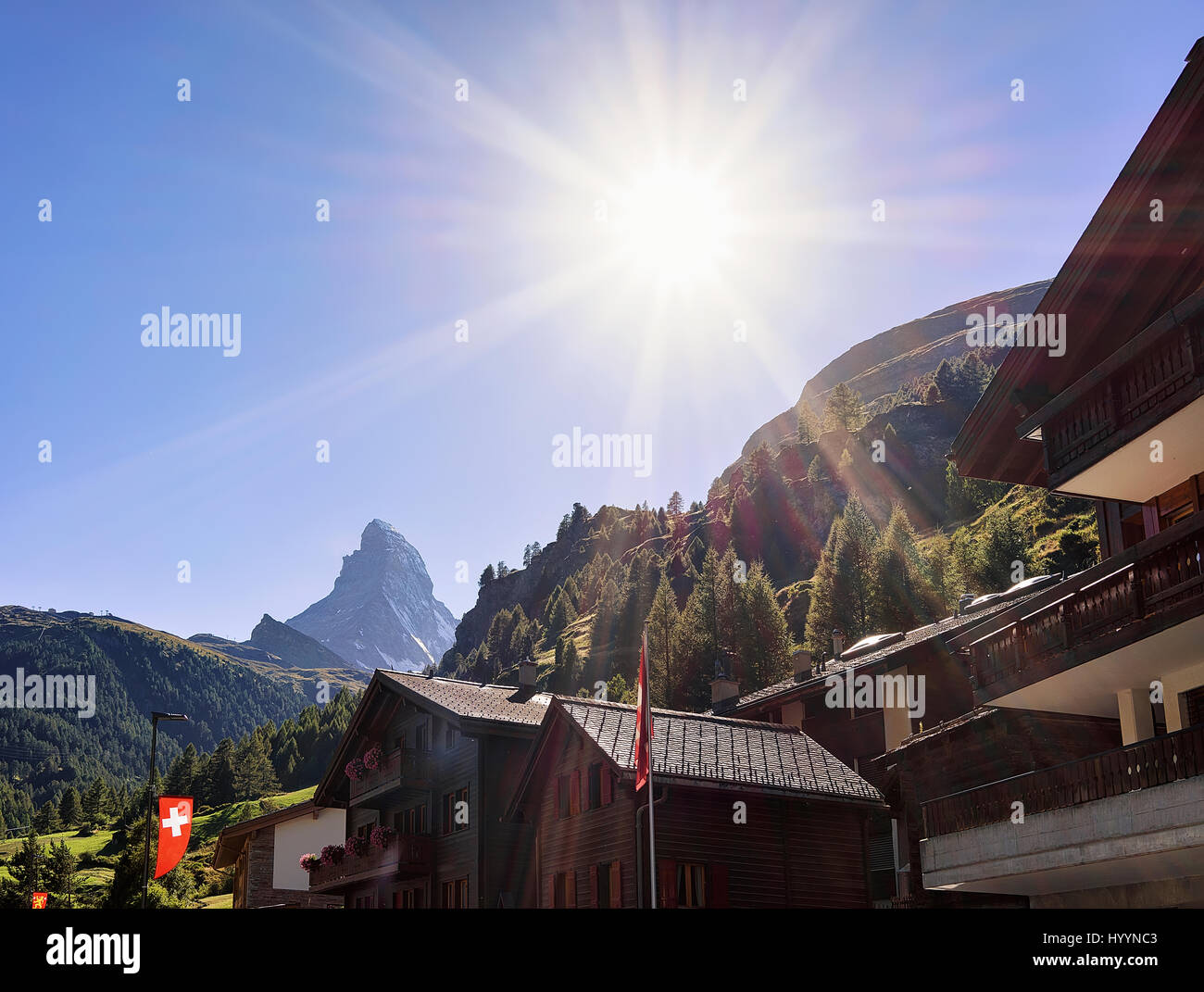 Traditional Swiss Chalets in Zermatt with Matterhorn summit with flags ...