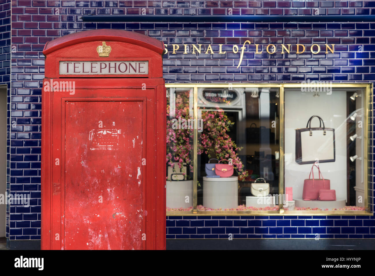 London - March 30: Iconic phone booth in front of shop with blue tile wall on March 30, 2017. Stock Photo