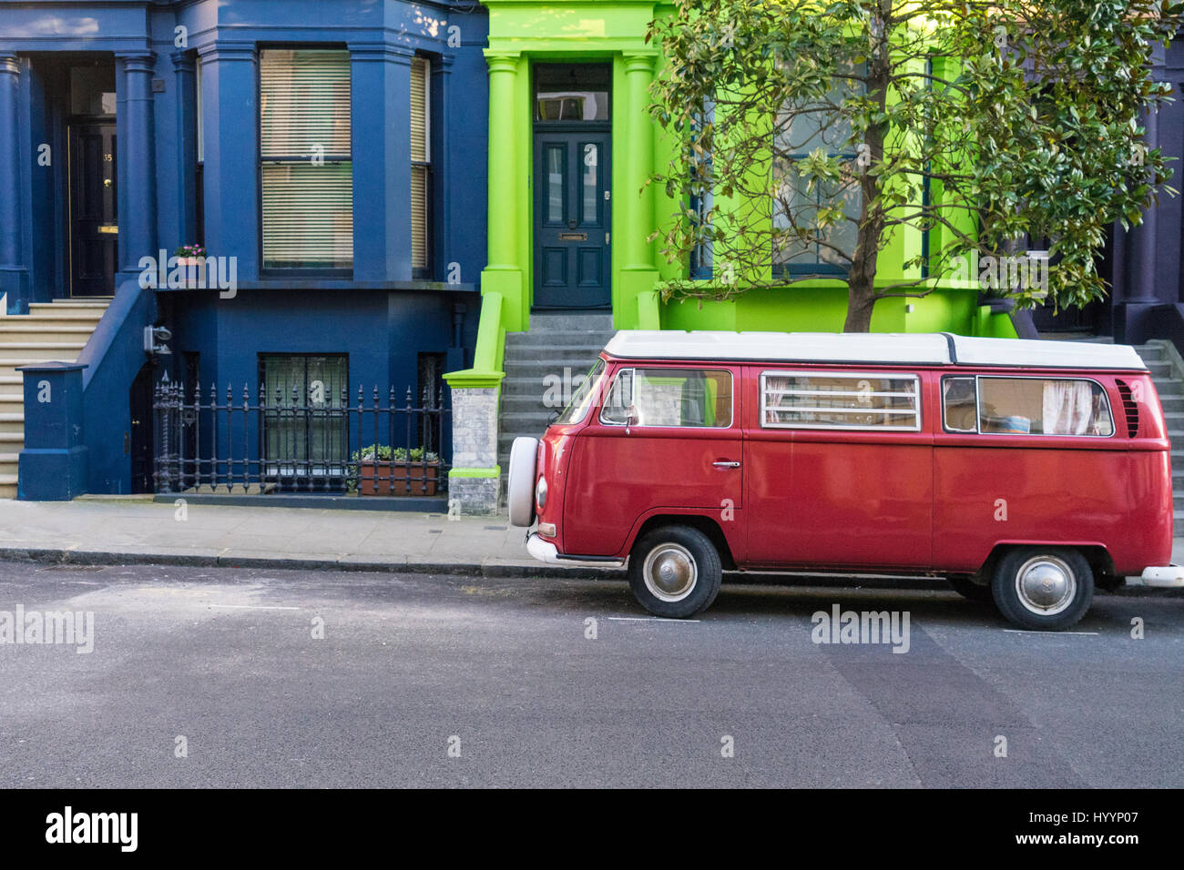 London - March 30: Colorful blue and green town houses and red oldtimer Volkswagen bus in Notting Hill on March 30, 2017. Stock Photo