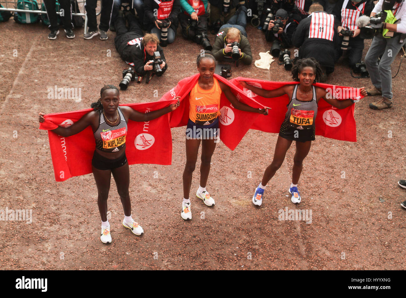 London, UK 24 April 2016. Kenyan runners Florence Kiplagat,  Jemima Sumgong (winner) and Tigist Tufa (Ethiopia) pose for photos after crossing te finish line  of  the Virgin Money London Marathon. © David Mbiyu/Alamy Live News Stock Photo