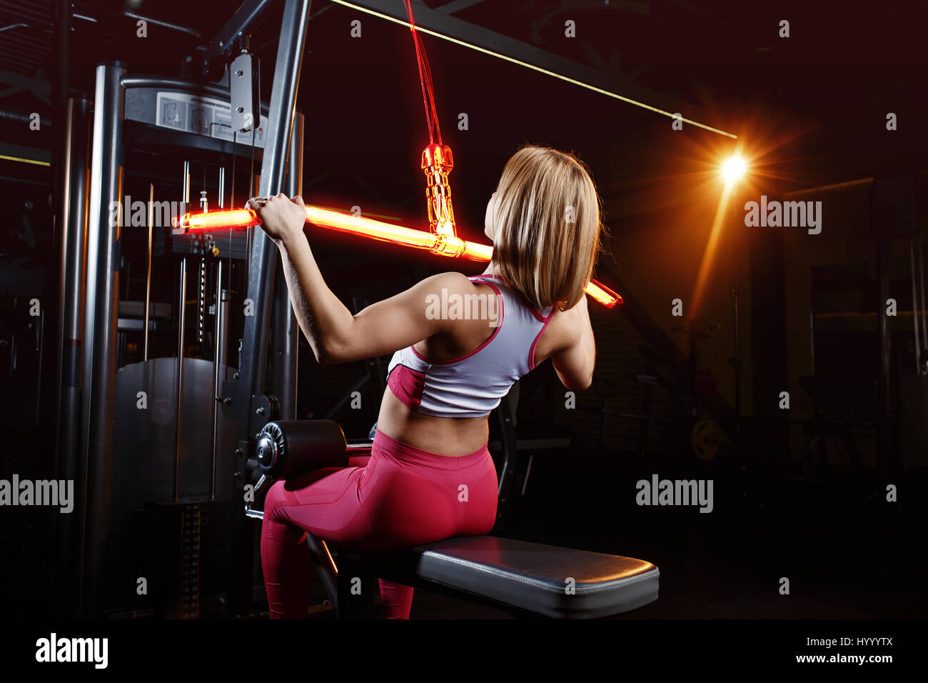 Young fitness woman doing exercises the major muscle groups in the gym. Strength training. Fiery training machine Stock Photo
