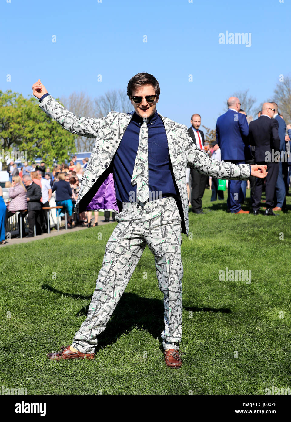 A racegoer wearing a suit with a dollar pattern poses on Grand National ...