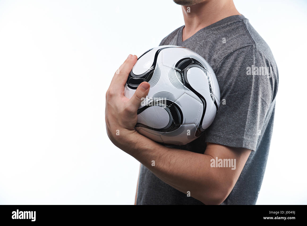 Sportsman in grey generic uniform hold ball close up isolated on white background Stock Photo