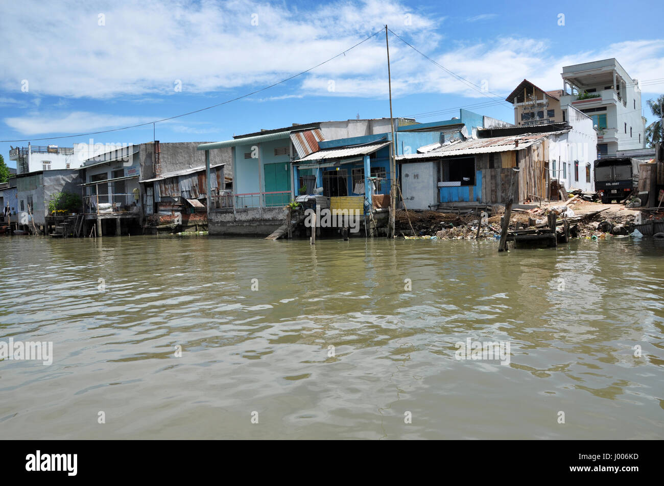 CAN THO, VIETNAM - FEBRUARY 17, 2013: Typical shack homes, riverside stils houses along the Mekong Delta. People from the suburbs are living in povert Stock Photo
