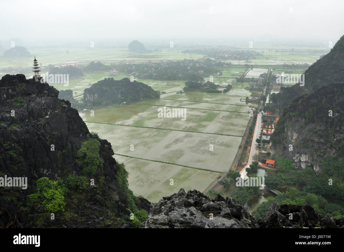 Panorama view of rice fields, limestone rocks and mountaintop pagoda ...