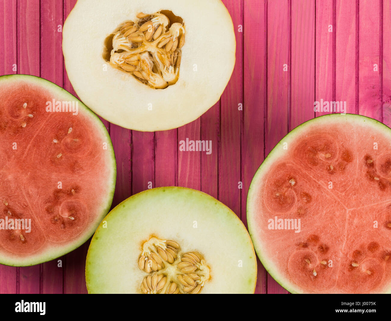 Water Melon Galia Melon and Honeydew Melon Against a Pink Background