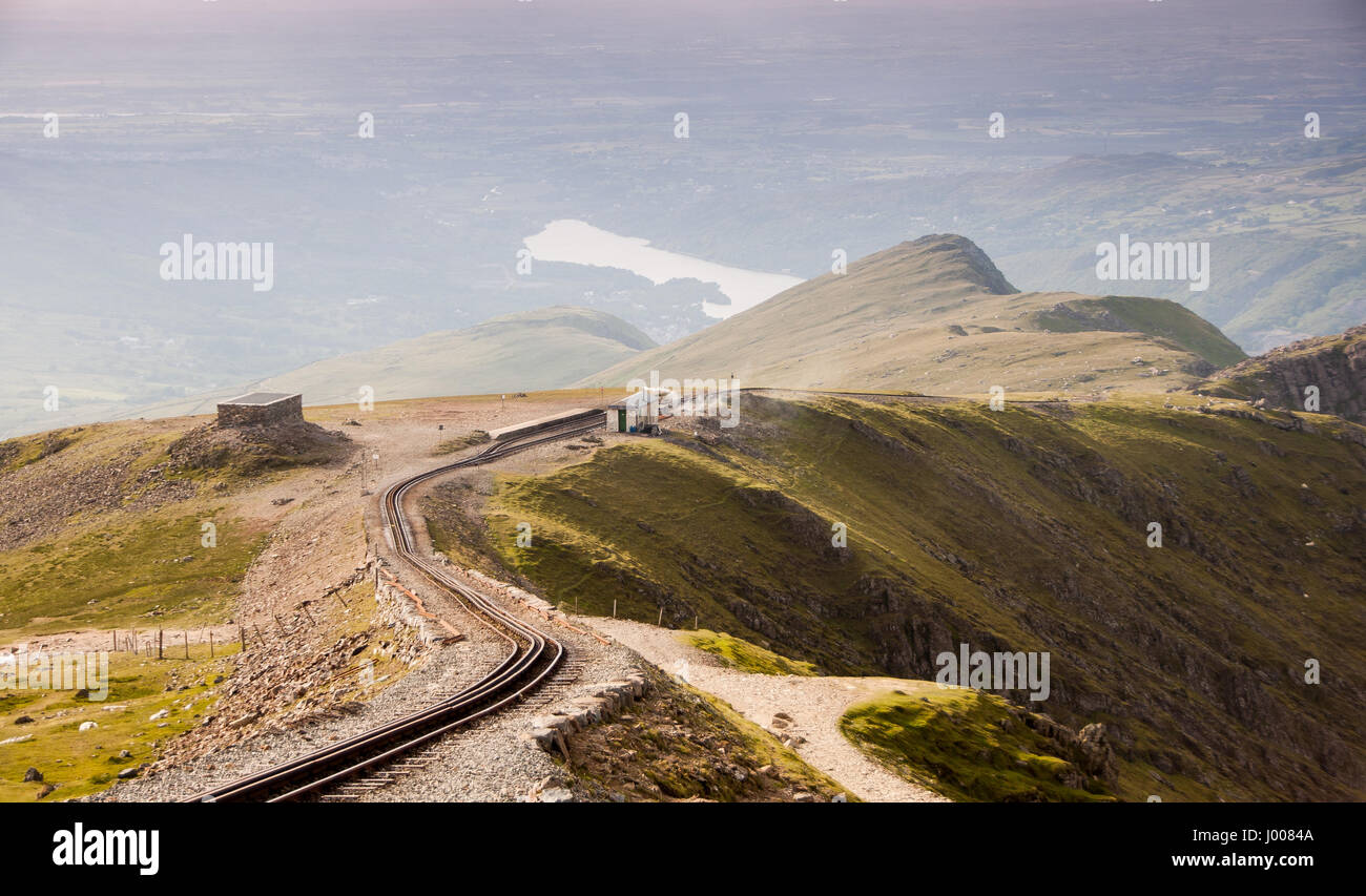 The view north from Snowdon mountain to Llanberis village and lake, with the Snowdon Mountain Railway tracks descending the ridgeway, in Snowdonia Nat Stock Photo