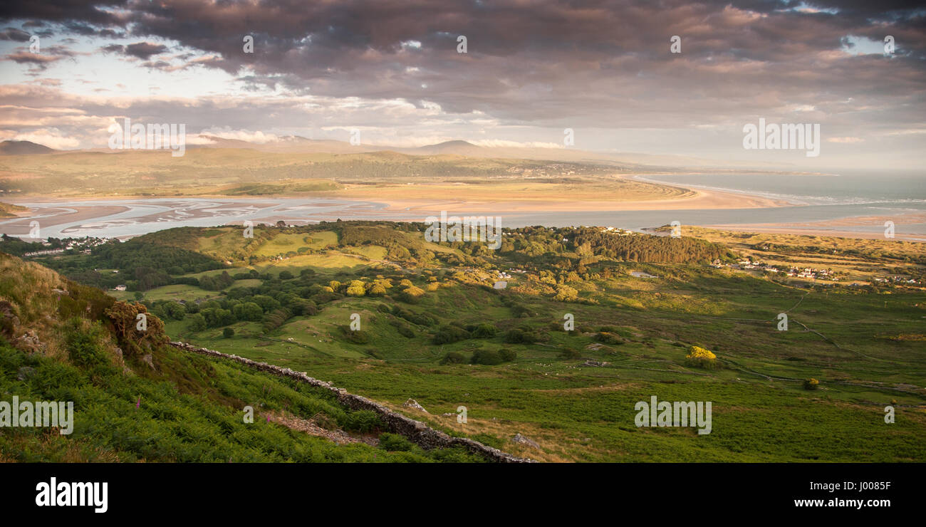 The sun sets on the estuary of the Afon Dwyryd river at Porthmadog in north Wales, viewed from Moel-y-Gest mountain in Snowdonia National Park. Stock Photo