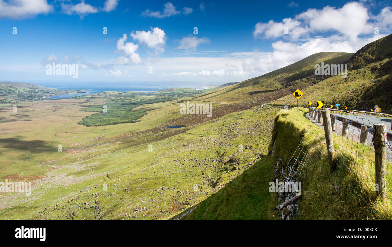 The Conor Pass road crosses the mountains of Ireland's Dingle Peninsula, above the Owenmore Valley and with Tralee Bay and the Atlantic Ocean beyond. Stock Photo