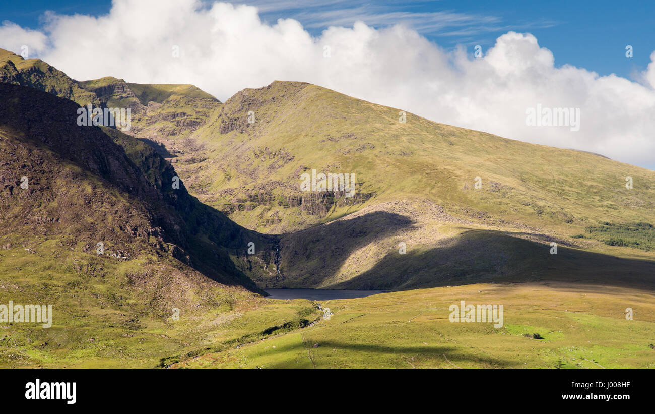 Cloud shadows pass over Brandon Mountain, one of Ireland's highest peaks, on County Kerry's Dingle Peninsula, viewed from the Conor Pass. Stock Photo