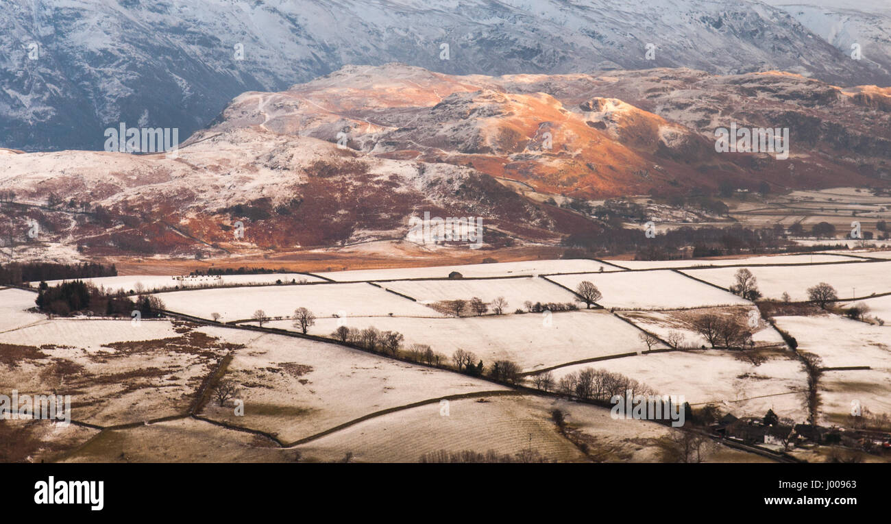 Winter snow lies on fields and mountains around Castlerigg stone circle in England's lake district. Stock Photo