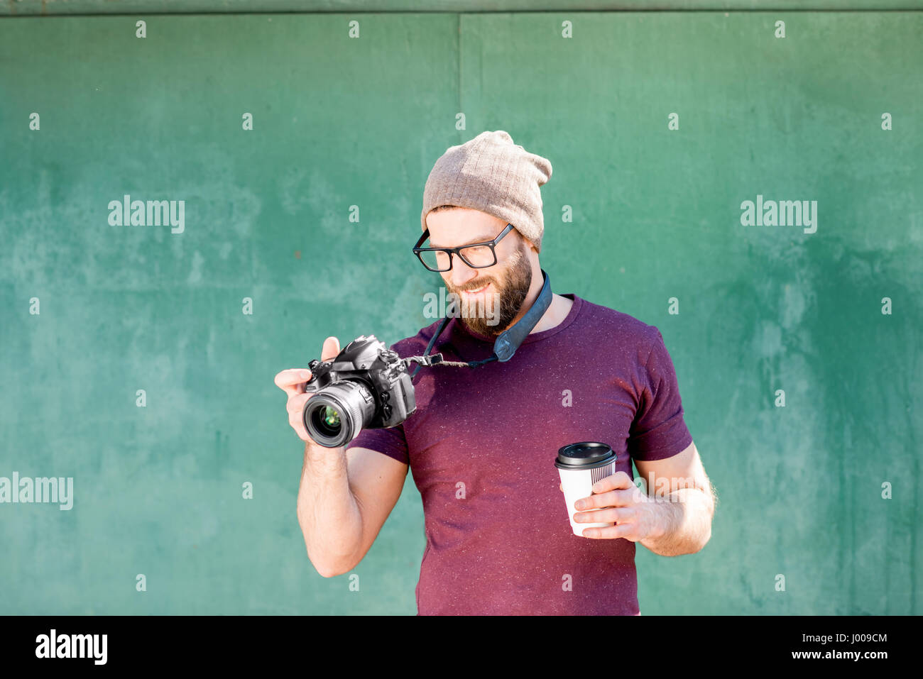 Portrait of photographer on the green background Stock Photo
