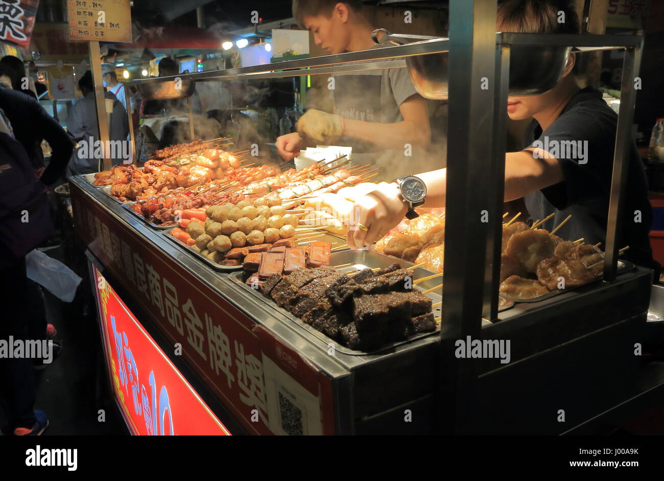 People cook traditional Taiwanese food at Raohe Night market in Taipei Taiwan. Raohe Night market is one of the oldest night markets in Taipei. Stock Photo